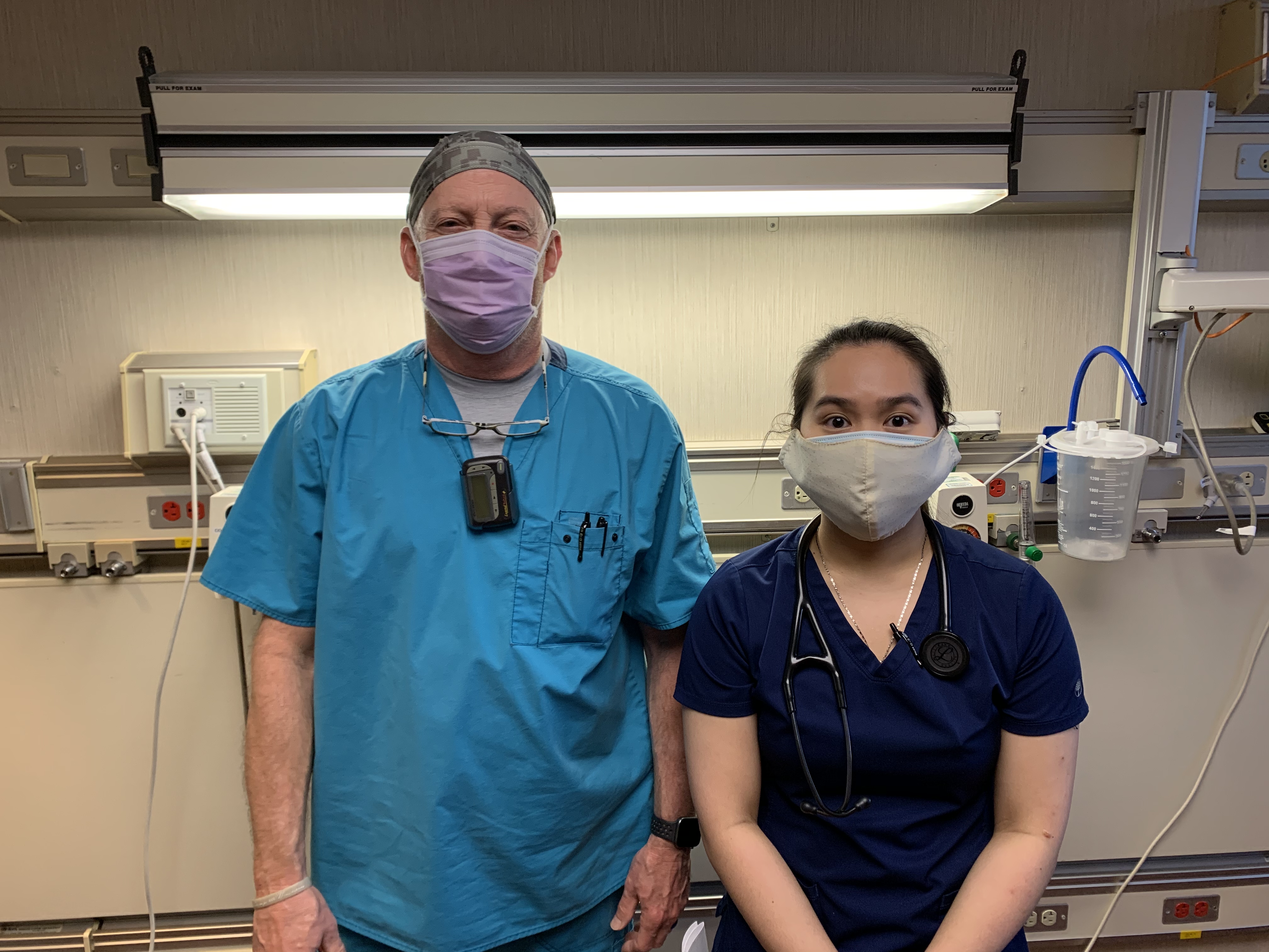 Doctor and nurse standing together wearing masks